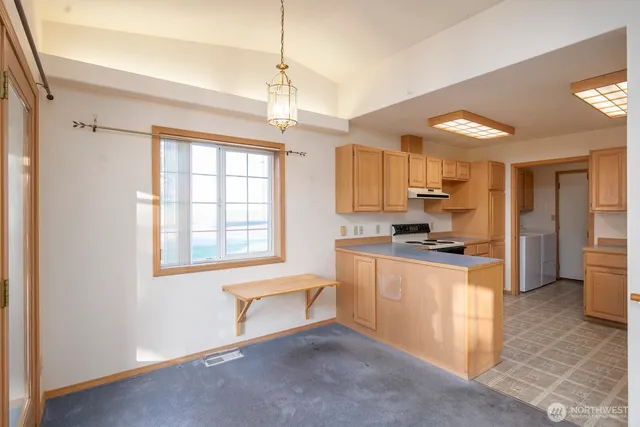 a large kitchen with stainless steel appliances granite countertop a stove and a refrigerator