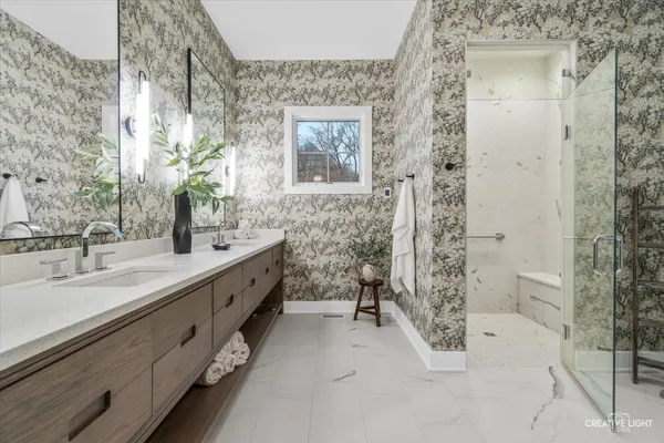 a spacious bathroom with double vanity and a mirror