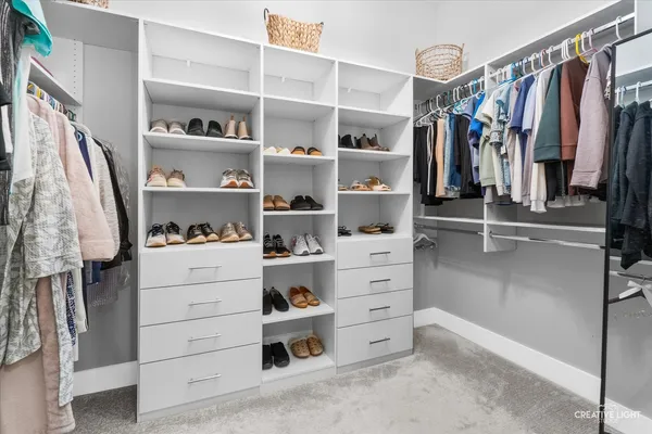 a view of walk in closet with clothes and shoes