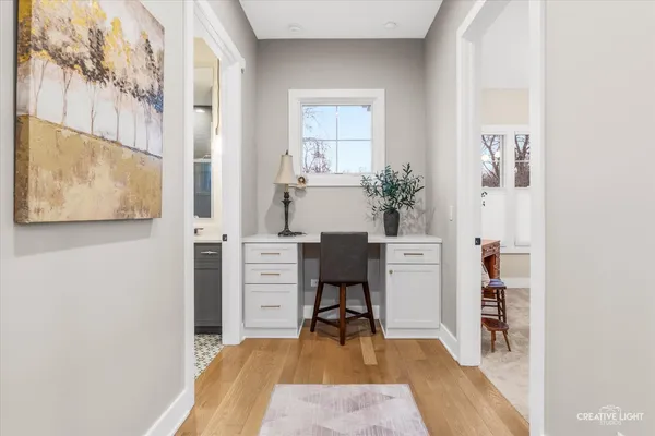 a view of a bedroom with workspace and wooden floor