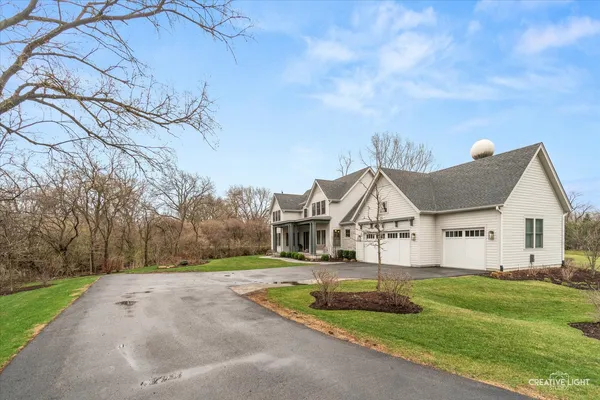 a view of house with garden and tall trees
