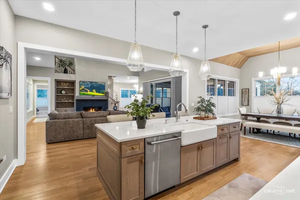 a large kitchen with stainless steel appliances kitchen island a large counter space a sink and living room view