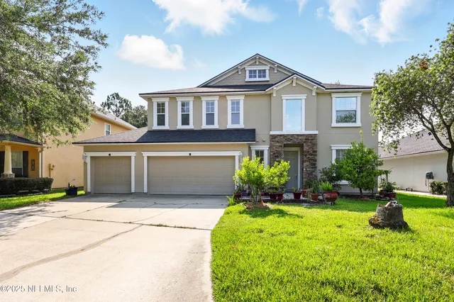 a front view of a house with a yard and garage