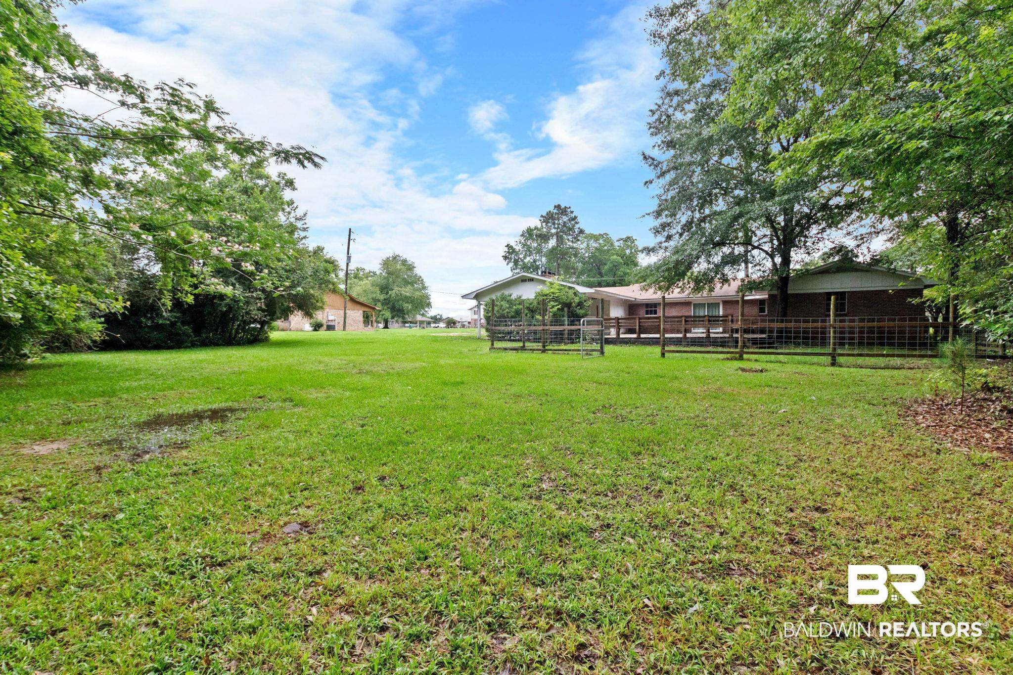 384 Old Bratt Road Atmore, AL 36502 - Photo 57 of 64 Expansive green yard with mature trees and a partial wooden fence