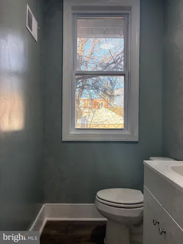 a bathroom with a toilet window and vanity