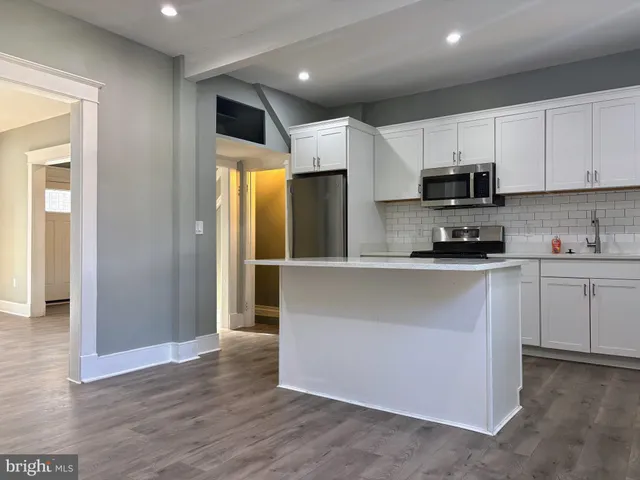 a kitchen with stainless steel appliances a refrigerator sink and microwave