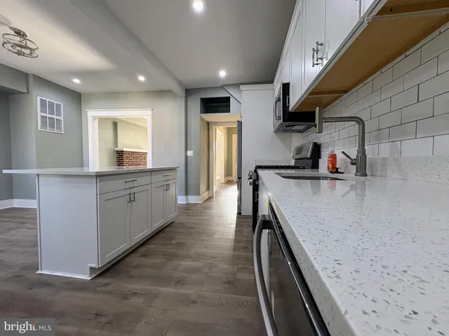 a kitchen with stainless steel appliances granite countertop a sink a stove and cabinets
