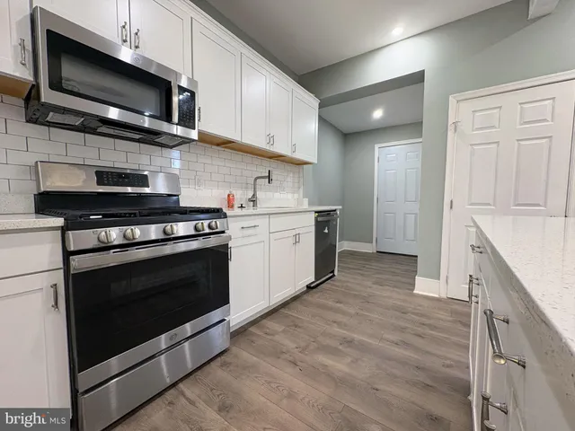 a kitchen with stainless steel appliances granite countertop a stove microwave and sink