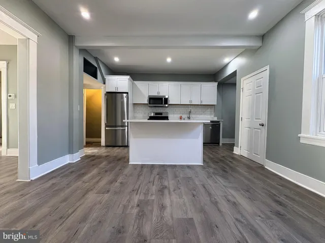 a view of kitchen with wooden floors and refrigerator