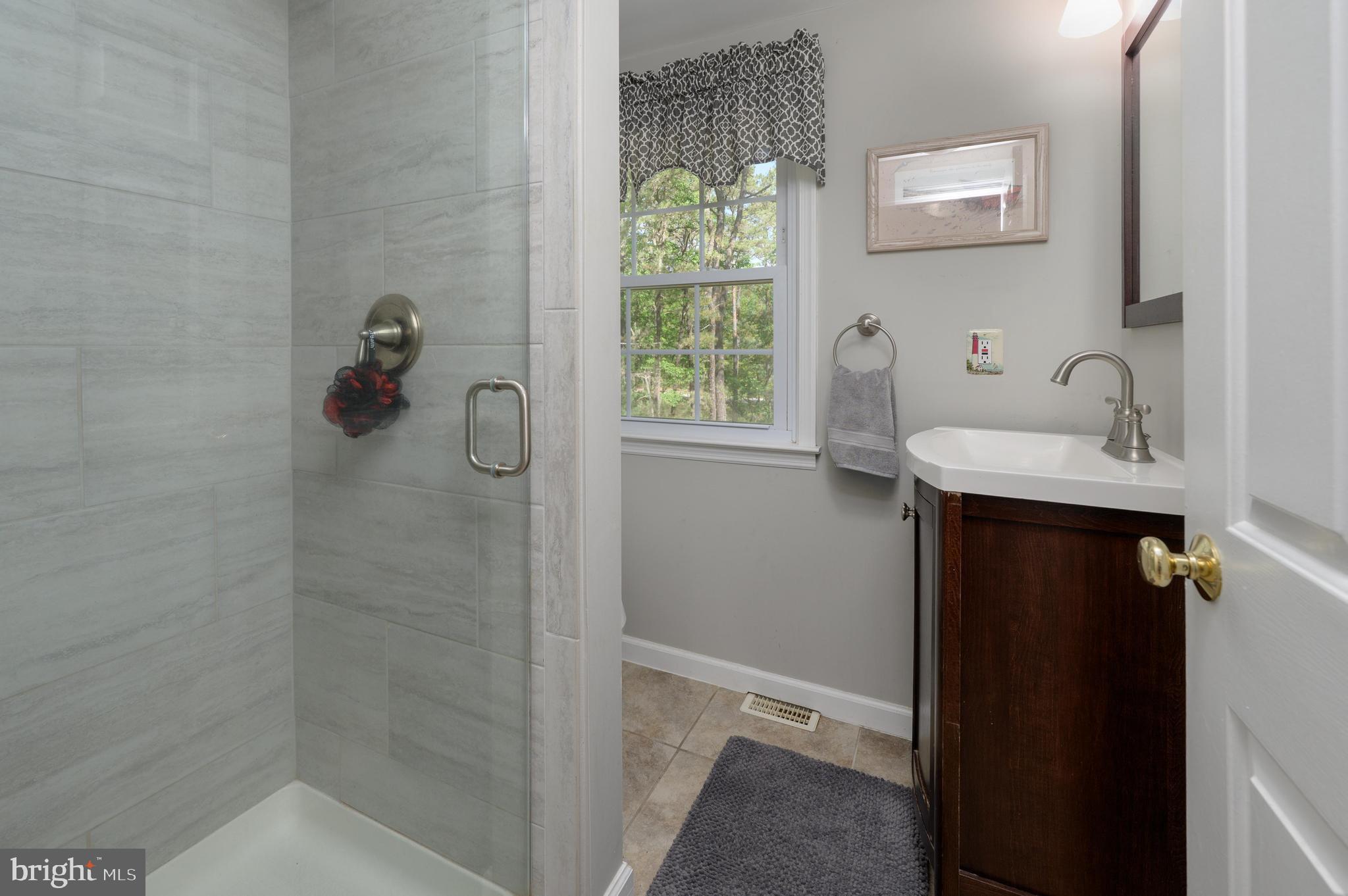 16 Sawmill Road Medford, NJ 08055 - Photo 15 of 37 a bathroom with a sink a window and shower