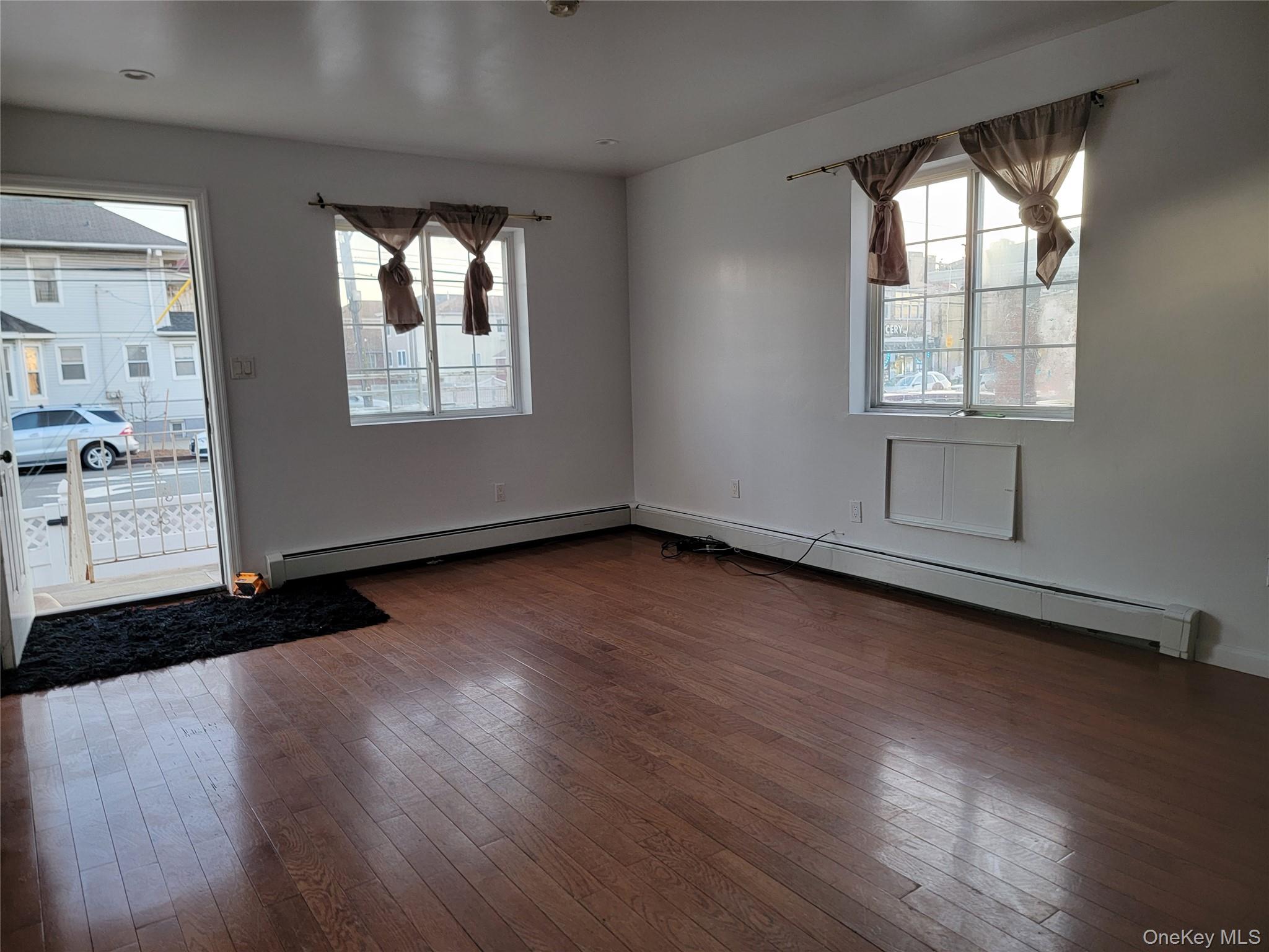 69-06 Beach Channel Drive Queens, NY 11692 - Photo 8 of 15 an empty room with wooden floor and windows