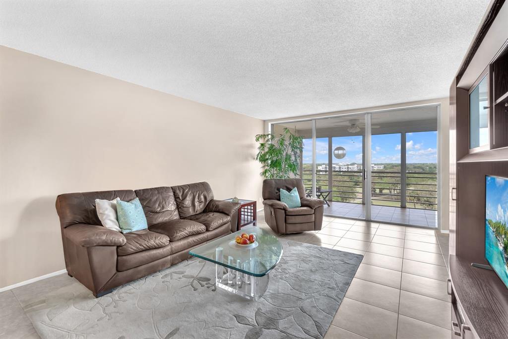 605 Oaks Drive, Unit 907 Pompano Beach, FL 33069 - Photo 11 of 41 a living room with furniture and a floor to ceiling window