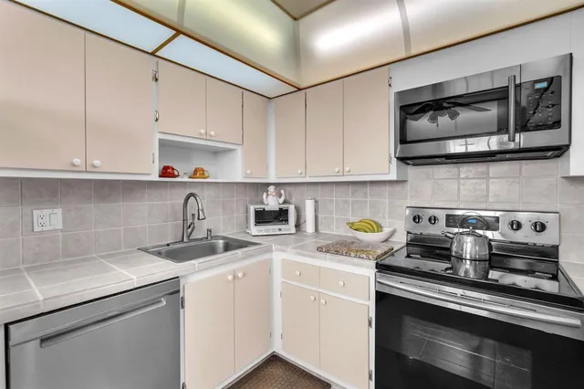 a bathroom with a granite countertop sink a toilet and a mirror