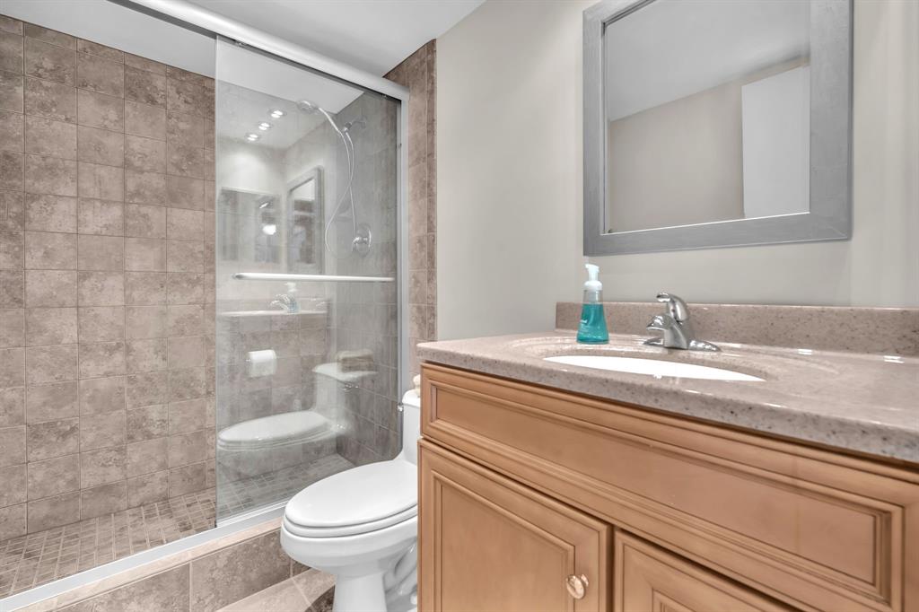 605 Oaks Drive, Unit 907 Pompano Beach, FL 33069 - Photo 9 of 41 a bathroom with a granite countertop sink a toilet and a mirror