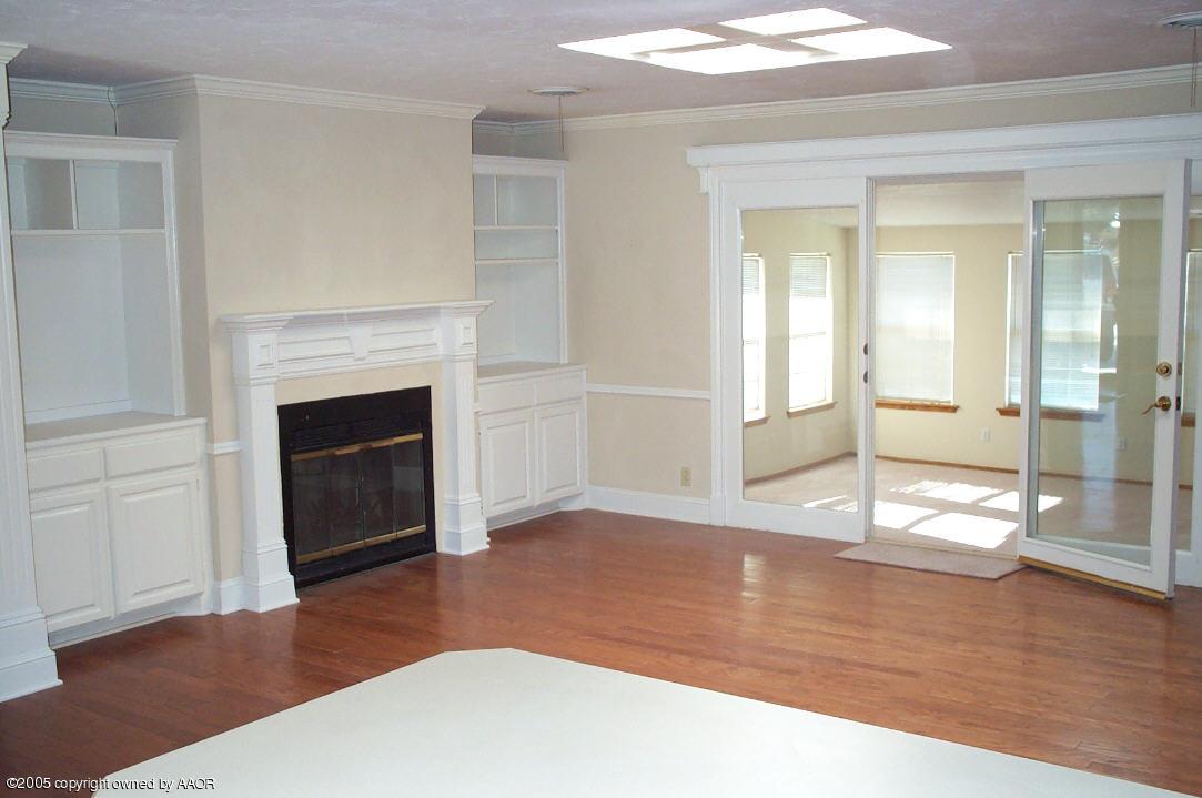 7922 Goodnight Trail Amarillo, TX 79110 - Photo 8 of 18 a view of empty room with wooden floor and fireplace
