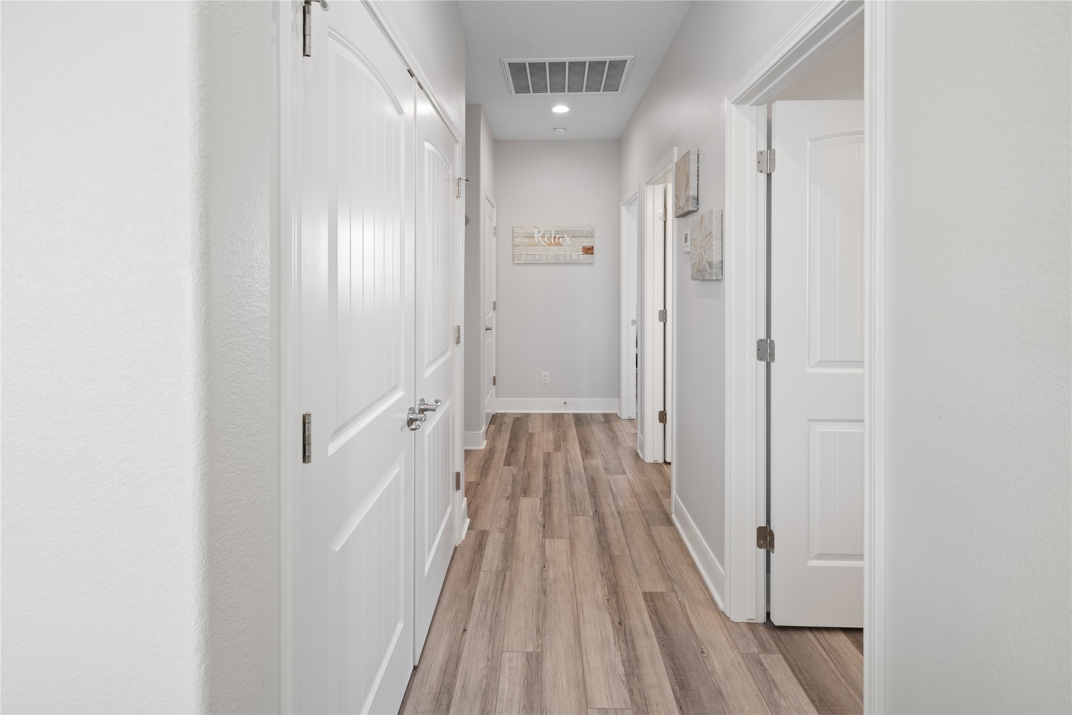 1286 Lagoon Drive Crystal Beach, TX 77650 - Photo 26 of 45 a view of a hallway with wooden floor and a bathroom