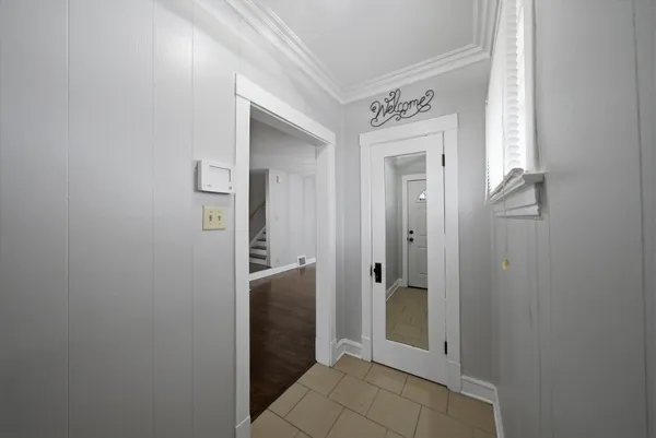 an empty room with wooden floor chandelier fan and windows