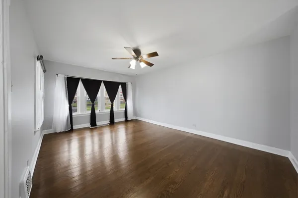 a view of empty room with wooden floor