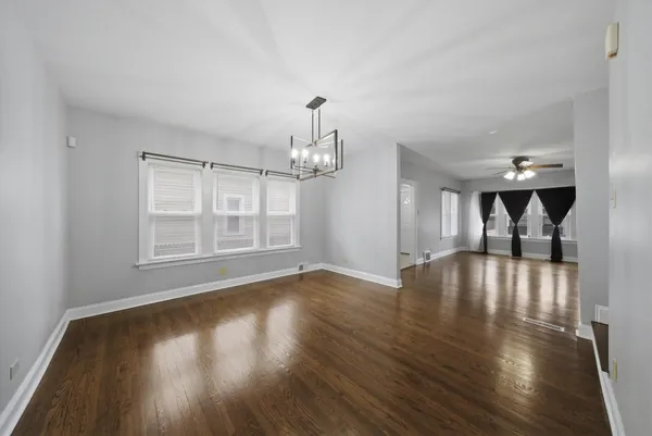 a view of empty room with wooden floor and ceiling fan