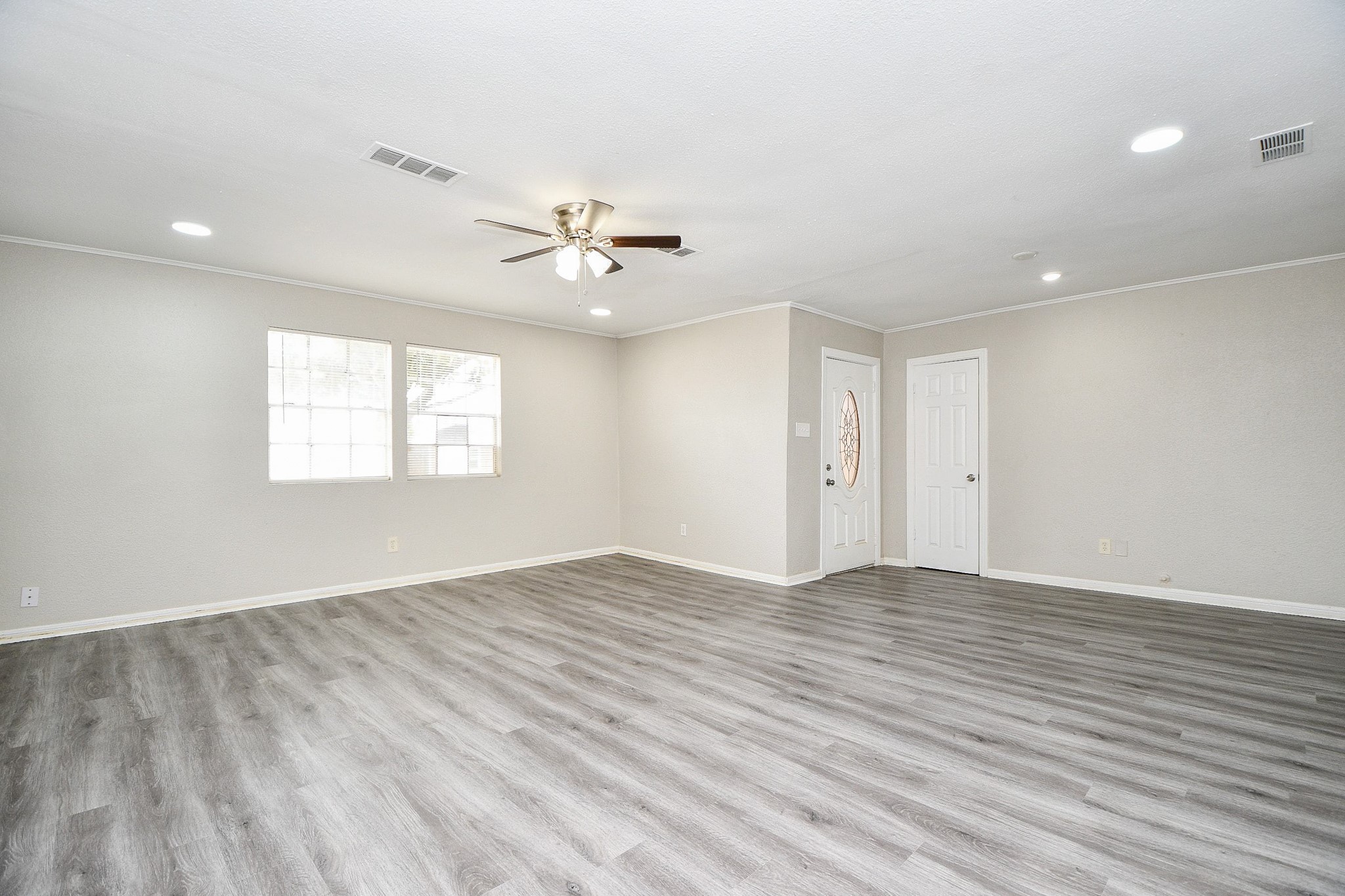 1606 Harris Avenue Pasadena, TX 77506 - Photo 4 of 20 Spacious living area with modern laminate flooring, neutral walls, and recessed lighting.