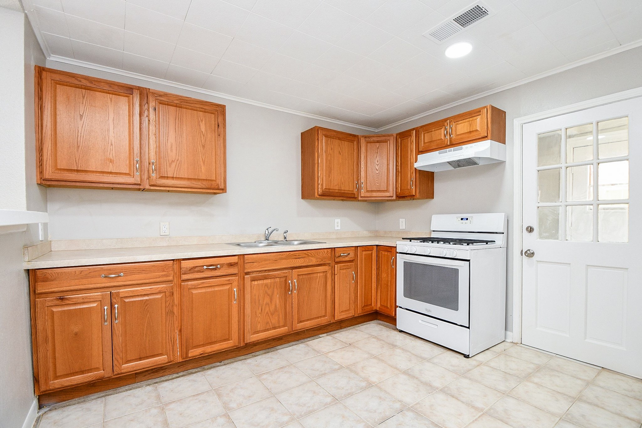 1606 Harris Avenue Pasadena, TX 77506 - Photo 6 of 20 Equipped with light wood cabinetry, a white gas stove, and neutral tile flooring.
