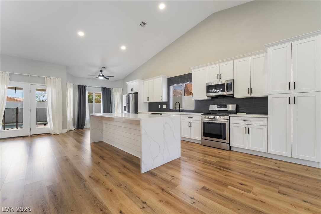 9171 West Viking Road Las Vegas, NV 89147 - Photo 17 of 43 Culinary dreams come alive in this kitchen, boasting an island with abundant counter space and gleaming stainless steel appliances.