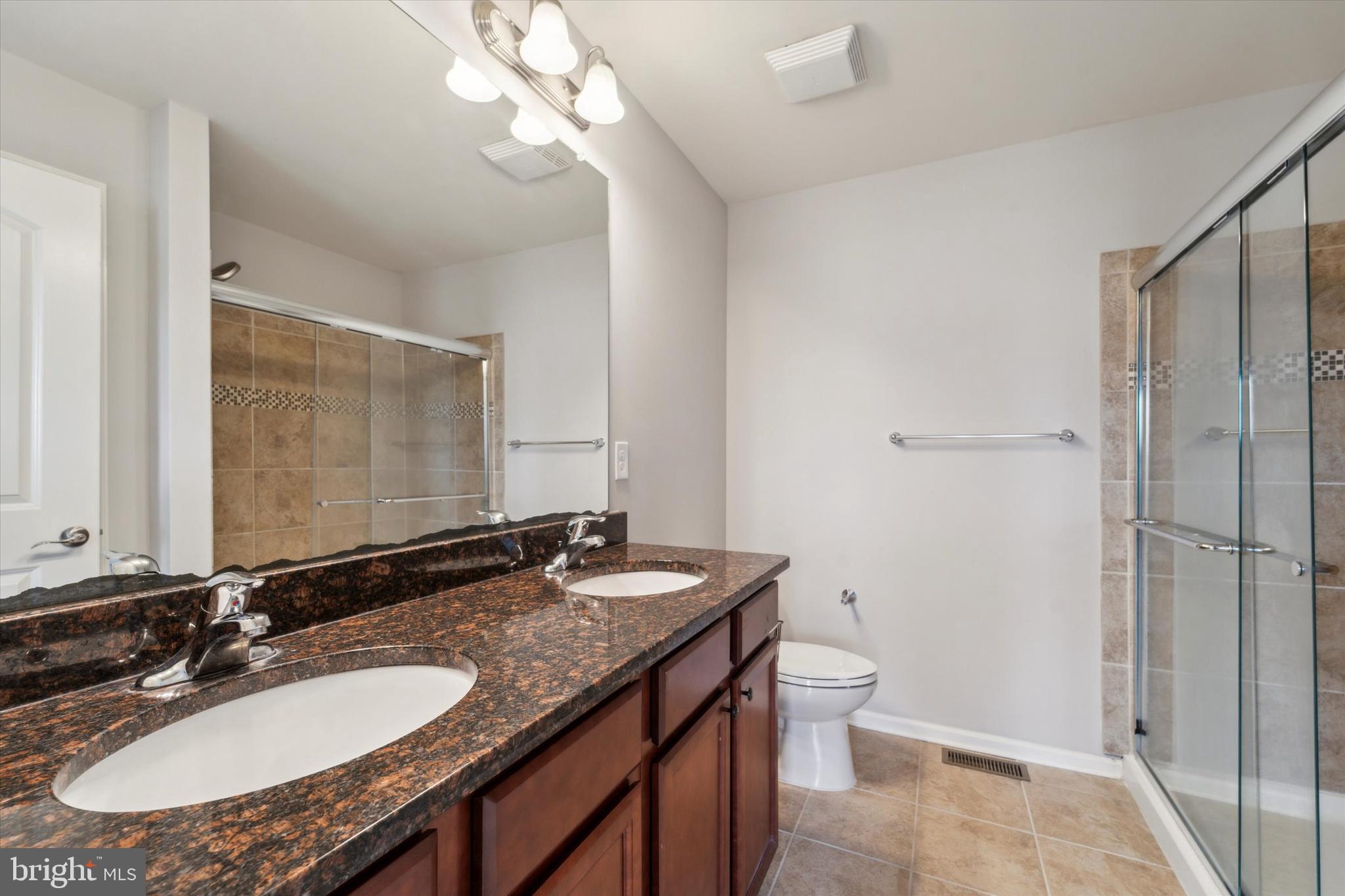 3799 Jacob Stout Road, Unit 5 Doylestown, PA 18902 - Photo 12 of 25 a bathroom with a granite countertop sink a toilet a mirror and shower