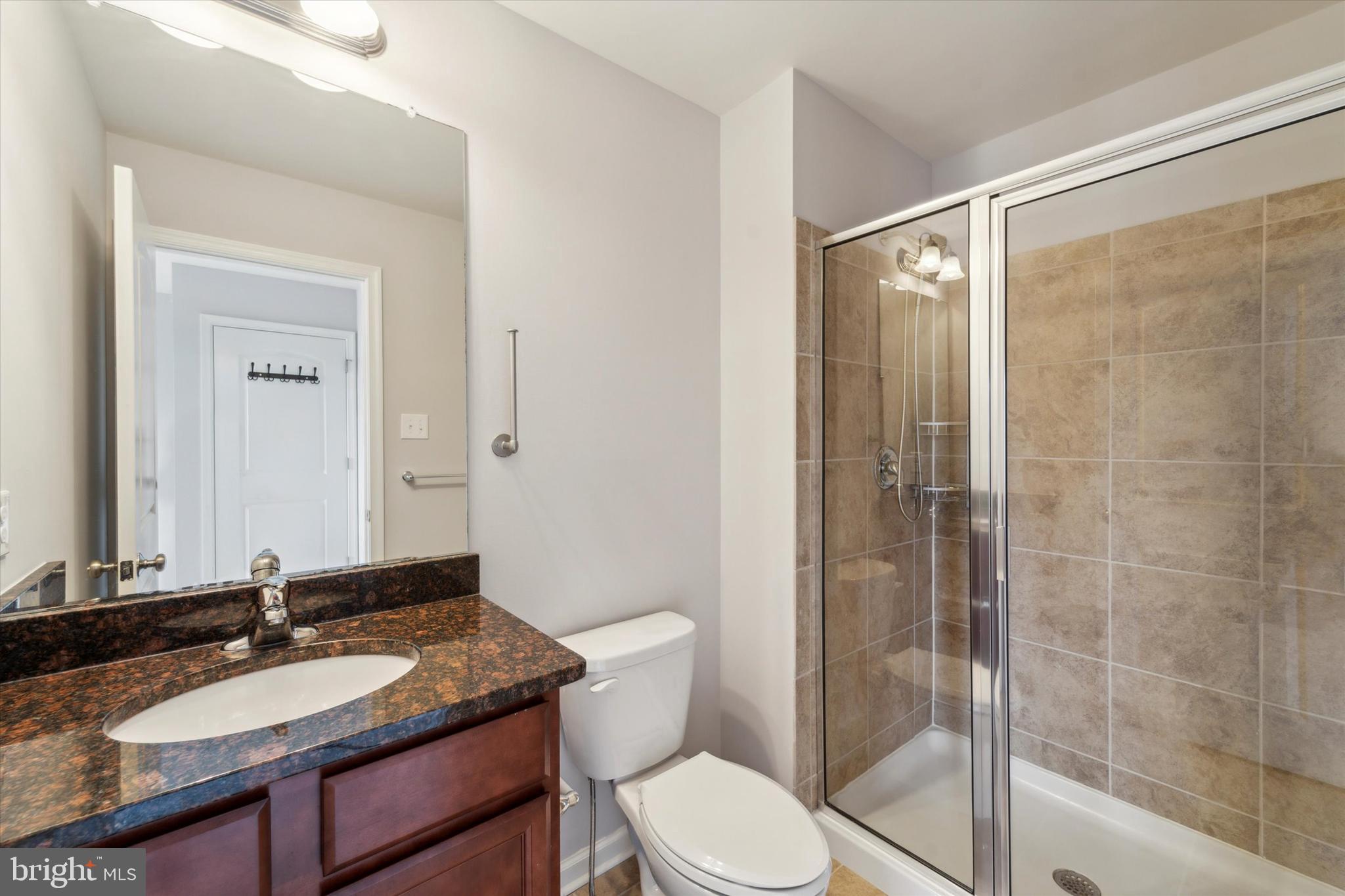 3799 Jacob Stout Road, Unit 5 Doylestown, PA 18902 - Photo 18 of 25 a bathroom with a granite countertop sink toilet a mirror and shower