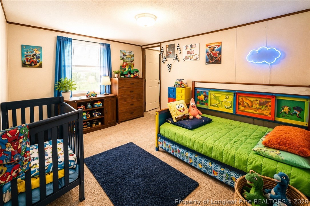 466 Ralph Hunt Boulevard Orrum, NC 28369 - Photo 10 of 17 a bedroom with three beds and a book shelf