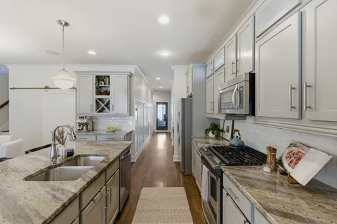a kitchen with stainless steel appliances granite countertop a sink stove and refrigerator