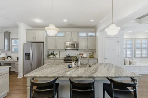 a kitchen with refrigerator a sink and chairs