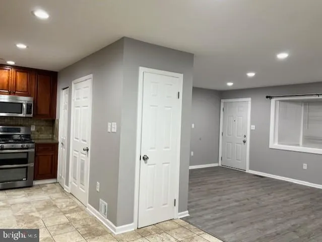 a view of a kitchen with a refrigerator a stove top oven and cabinets