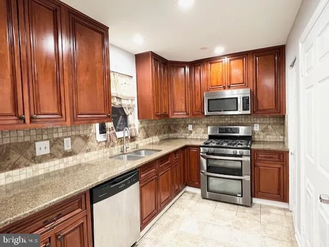 a kitchen with stainless steel appliances granite countertop a stove a sink dishwasher and a microwave