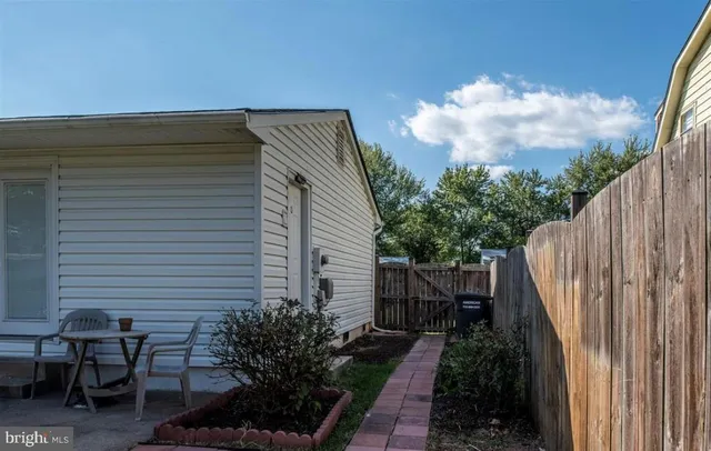 a view of backyard with a tub and wooden fence