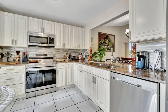 a kitchen with stainless steel appliances granite countertop a stove a sink and a microwave