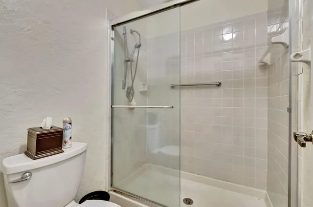 a bathroom with a shower a toilet and a sink