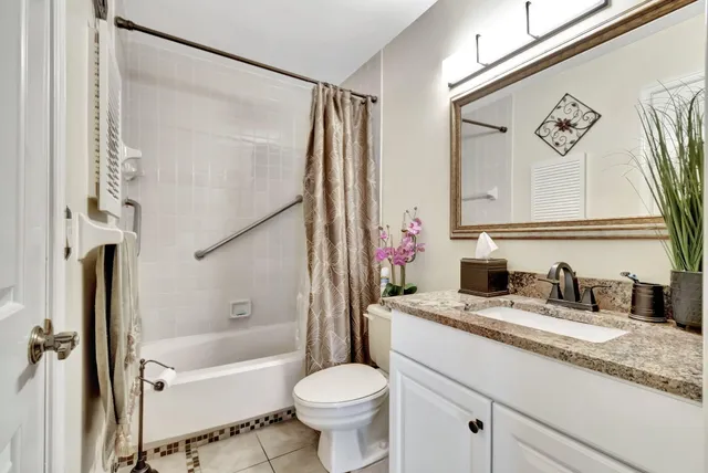 a bathroom with a granite countertop sink toilet and shower