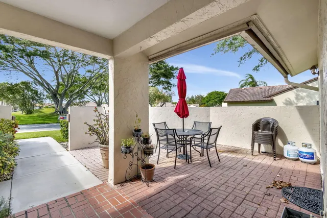 a view of a patio with table and chairs and potted plants