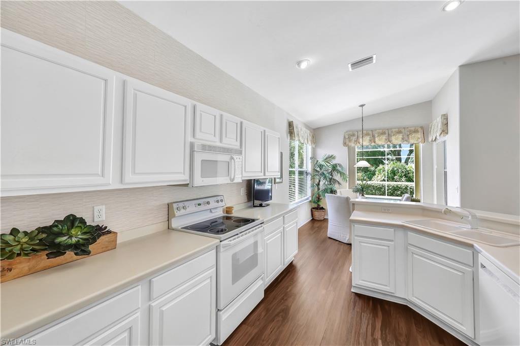1721 Marsh Run Naples, FL 34109 - Photo 19 of 35 a kitchen with a white stove top oven and white cabinets
