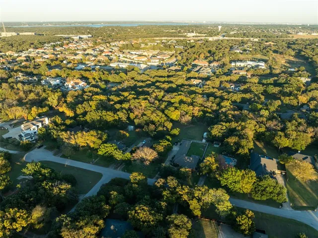 an aerial view of residential houses with outdoor space and trees