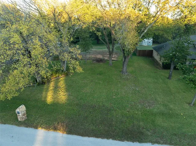 a view of a house with a big yard and large trees