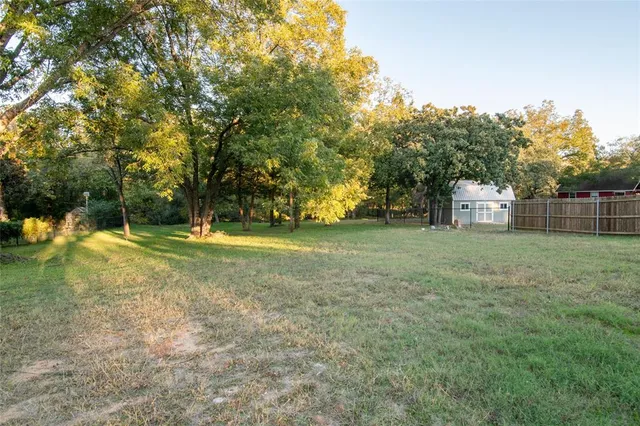 a view of a yard with large trees