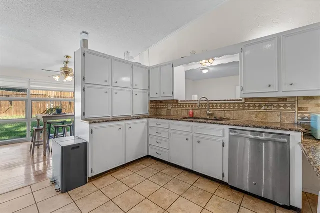 a kitchen with granite countertop cabinets and chairs