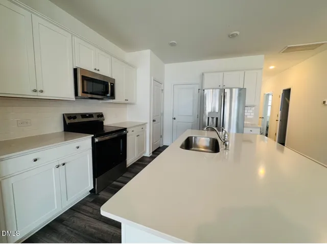 a kitchen with a sink a stove and refrigerator