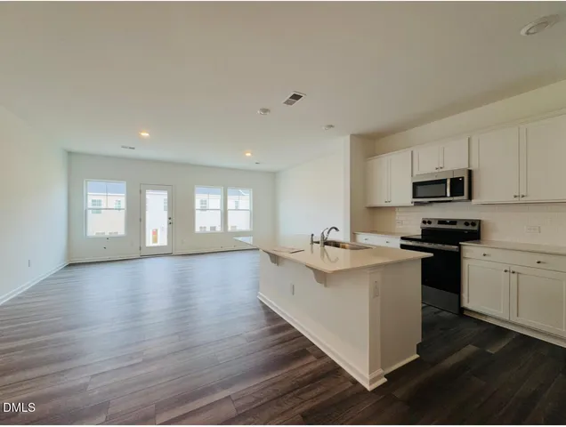 a kitchen with stainless steel appliances a refrigerator stove and microwave