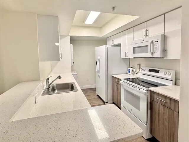 a kitchen with stainless steel appliances a sink a stove a refrigerator and cabinets
