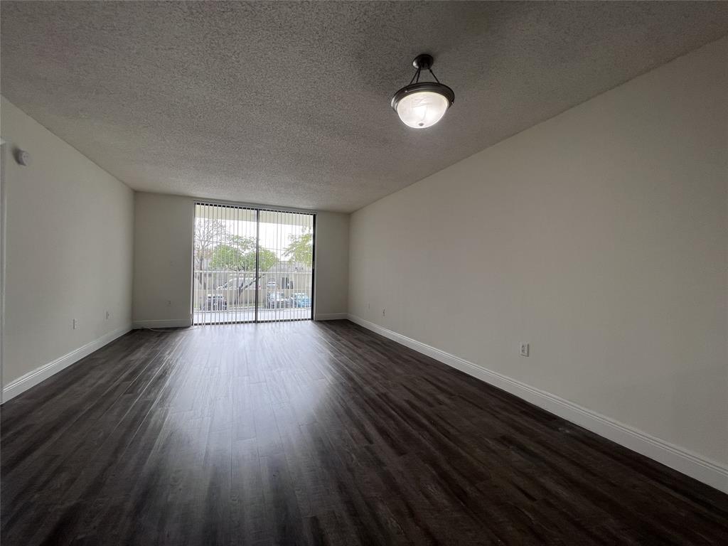 18335 Northwest 68th Avenue, Unit 245208 Hialeah, FL 33015 - Photo 3 of 18 a view of a livingroom with wooden floor and a window