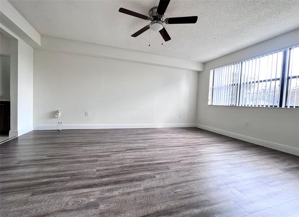 18335 Northwest 68th Avenue, Unit 245208 Hialeah, FL 33015 - Photo 9 of 18 an empty room with wooden floor and windows