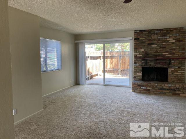 3240 Gypsum Road Reno, NV 89503 - Photo 11 of 14 a view of an empty room with a fireplace and a window