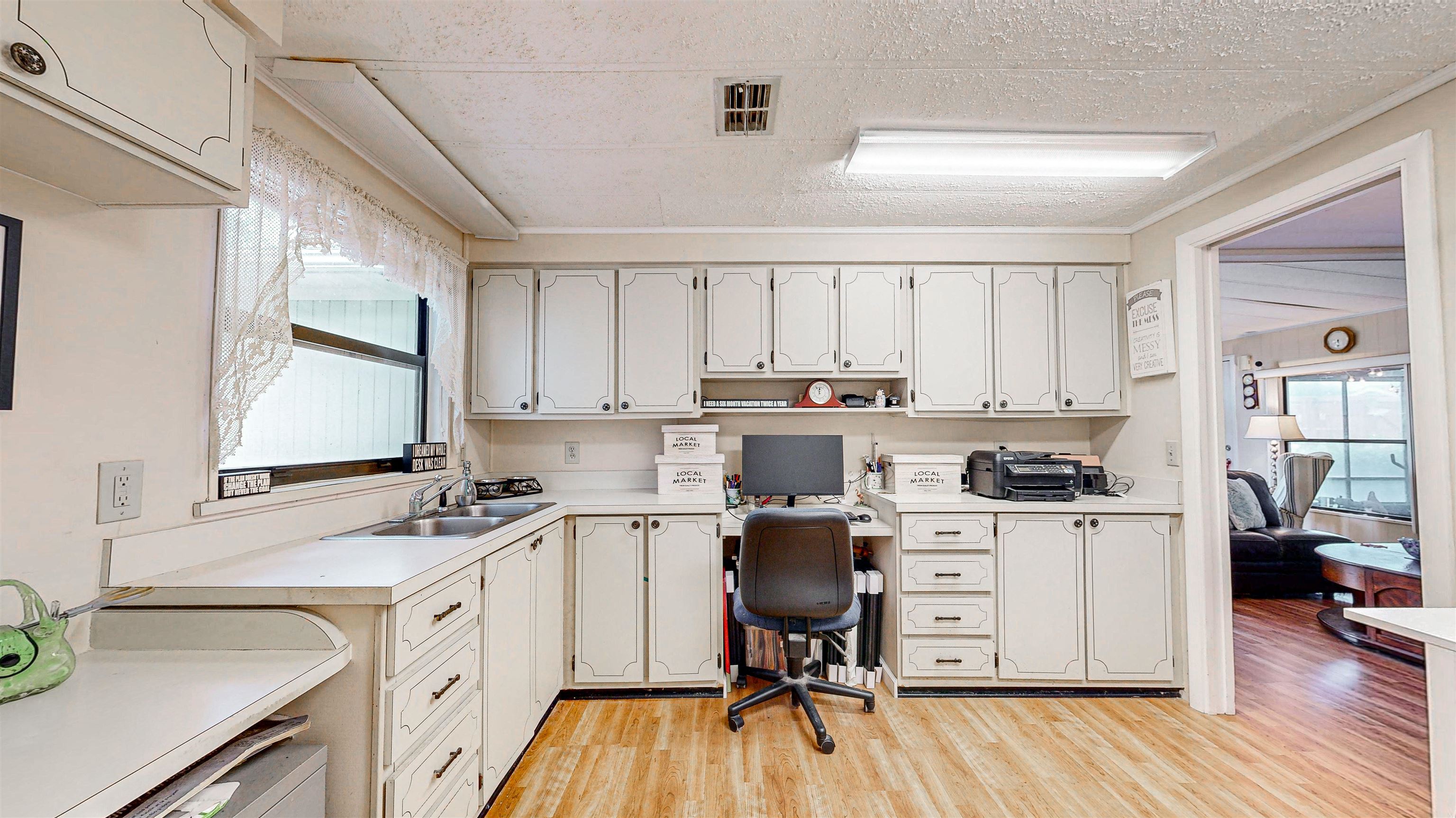 224 Puebla Road St. Augustine, FL 32080 - Photo 11 of 32 a view of a kitchen counter space a sink wooden floor and a window